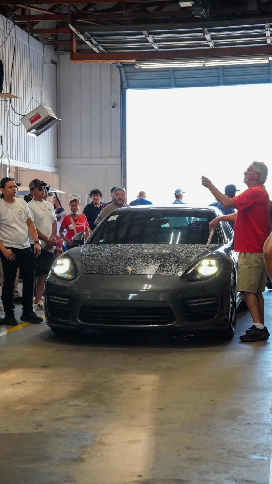 Buyers gathered around a Porsche in the auction lane at Atlanta East Auto Auction